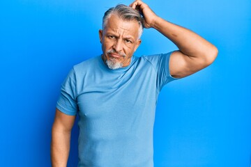 Wall Mural - Middle age grey-haired man wearing casual clothes confuse and wonder about question. uncertain with doubt, thinking with hand on head. pensive concept.