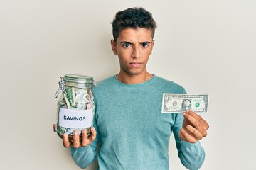 Sticker - Young handsome african american man holding jar with savings skeptic and nervous, frowning upset because of problem. negative person.