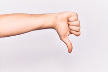 Close Up Of Hand Of Young Caucasian Man Over Isolated Background Doing Thumbs Down Rejection Gesture, Disapproval Dislike And Negative Sign