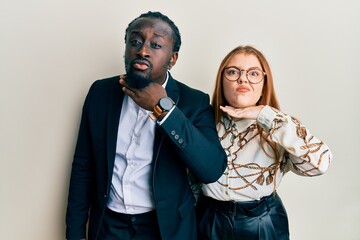 Sticker - Young interracial couple wearing business and elegant clothes cutting throat with hand as knife, threaten aggression with furious violence