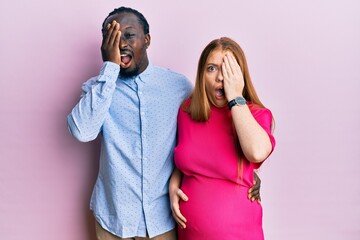 Poster - Young interracial couple expecting a baby, touching pregnant belly yawning tired covering half face, eye and mouth with hand. face hurts in pain.