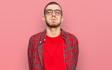 Hispanic young man wearing casual clothes puffing cheeks with funny face. mouth inflated with air, crazy expression.