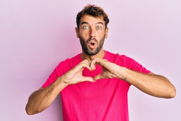 Sticker - Handsome man with beard making heart symbol with hands shape afraid and shocked with surprise and amazed expression, fear and excited face.