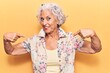 © Krakenimages.com - Senior grey-haired woman wearing casual clothes looking confident with smile on face, pointing oneself with fingers proud and happy.