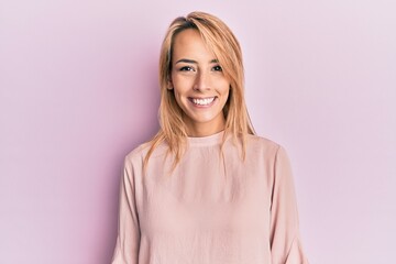 beautiful blonde woman wearing casual winter sweater looking positive and happy standing and smiling