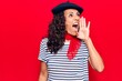 © Krakenimages.com - Middle age beautiful woman wearing french beret shouting and screaming loud to side with hand on mouth. communication concept.