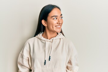 Canvas Print - Young asian woman wearing casual sweatshirt looking to side, relax profile pose with natural face and confident smile.