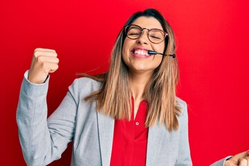 Poster - Beautiful brunette woman working at the office wearing operator headset very happy and excited doing winner gesture with arms raised, smiling and screaming for success. celebration concept.