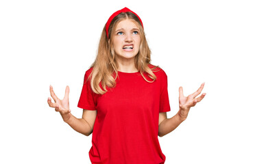 Wall Mural - Beautiful young caucasian girl wearing casual red t shirt crazy and mad shouting and yelling with aggressive expression and arms raised. frustration concept.