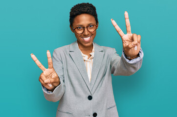 Wall Mural - Young african american woman wearing business clothes smiling with tongue out showing fingers of both hands doing victory sign. number two.