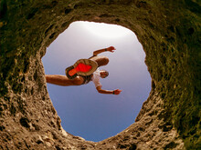 Low Angle View Of Man Jumping On Rock Formation