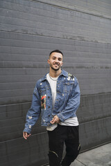 Canvas Print - Vertical shot of a young trendy male in streetwear posing and smiling