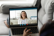 © fizkes - Close up back view of woman talk speak on video call with smiling Caucasian friend or colleague. Female have webcam digital virtual conference with client, engaged in online meeting on laptop.
