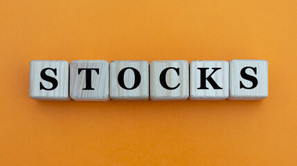 STOCKS - word on wooden cubes on a beautiful yellow background