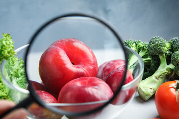 Wall Mural - view through magnifying glass on plums, closeup. poison detection