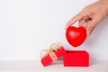 Canvas Print - Valentine day, hand open red gift box put heart, celebration and anniversary with giving love, donate and aid with heart shape symbol, charity and health, copy space, holiday and festive concept.