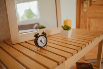 Sticker - Selective focus shot of a black alarm clock on the wooden table