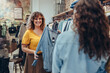 © Jacob Lund - Saleswoman assisting customer in clothing store