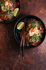 Wall Mural - Stir fried noodles with shrimps and vegetables in a wok on dark