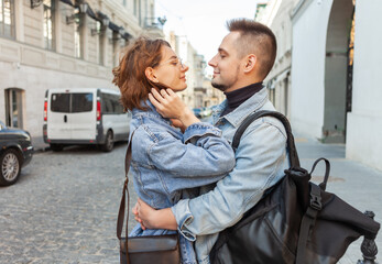 Wall Mural - Charismatic smiling couple in denim jackets on urban street