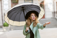 Beautiful Woman With Umbrella Checking For Rain