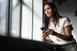 © Wavebreak Media - Mxed race businesswoman standing by window using smartphone in modern office
