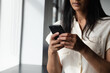 © Wavebreak Media - Mxed race businesswoman standing by window using smartphone in modern office