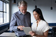 © Wavebreak Media - Diverse business people standing using digital tablet in modern office