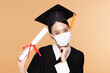 © 220 Selfmade studio - Attractive Asian woman graduated in cap and gown wear medical mask smile so proud and happiness due Virus outbrake and COVID-19 virus flu pandemic on Beige background,New normal of graduation concept