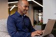 © Wavebreak Media - Mixed race businessman sitting using laptop in a modern office