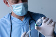 © Wavebreak Media - Caucasian male doctor wearing face mask standing and filling syringe
