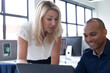© Wavebreak Media - Diverse business people sitting using a laptop talking in a modern office
