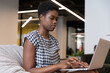 © Wavebreak Media - Mixed race businesswoman sitting using laptop in a modern office