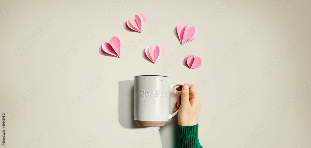 Female hand holding a mug with paper craft hearts - flat lay - obrazy, fototapety, plakaty 