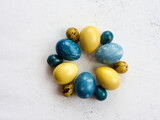 Fototapeta Desenie - painted Easter eggs (yellow, blue) on white background , top view