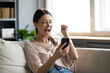 Close up overjoyed woman holding phone, screaming with joy, showing yes gesture, excited young female celebrating success, online lottery win, reading good news in email, using smartphone