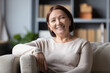 © fizkes - Head shot portrait positive mature woman with healthy smile sitting on cozy couch, happy middle aged female looking at camera, posing for photo at home, enjoying leisure time, relaxing on sofa alone