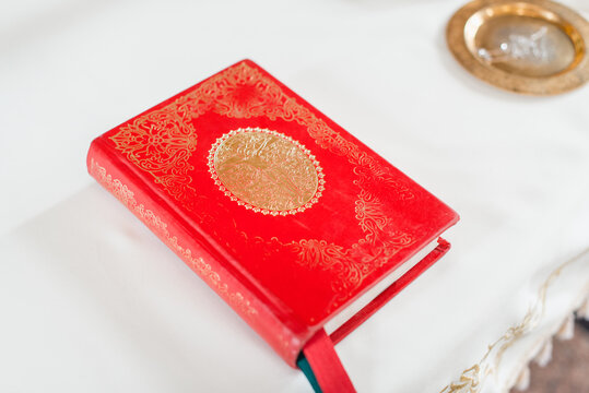 red hardcover holy bible on the white tablecloth. Selective focus