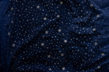 Background texture of blue fabric with a pattern of stars.