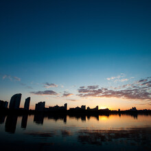 Square Photography. Sunset In The City. On The Front Plareka With The Reflection Of Dark Houses Along The Embankment.