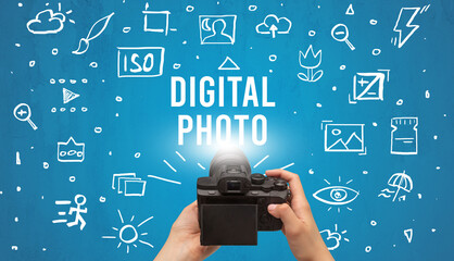 Hand taking picture with digital camera and DIGITAL PHOTO inscription, camera settings concept