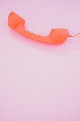 Canvas Print - Vertical shot of an orange handset on the purpl background