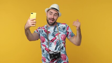 Wall Mural - Funny traveler tourist man in hat isolated on yellow background. Passenger traveling on weekend. Air flight journey concept. Doing selfie shot on mobile phone showing thumb up victory sign point aside