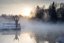 Woman Is Standing On The Wooden Bridge And Admire The Sunset Colored Thick Steam Evaporating From The Natural Spring During The Freezing Cold Winter Day