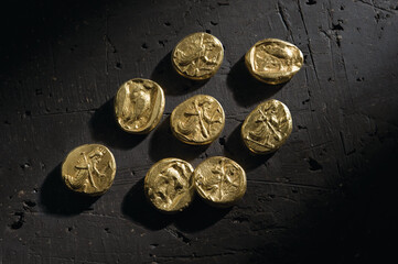 Wall Mural - Top view of ancient gold pieces on black surface