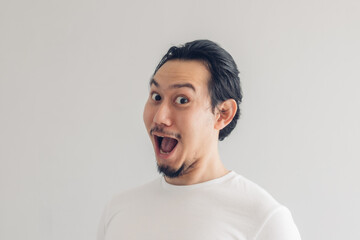 funny grinning smile face of asian man in white t-shirt and grey background.