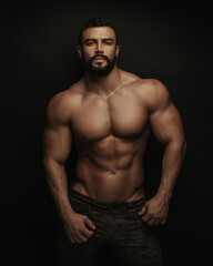 fitness handsome and shirtless man standing on black background
