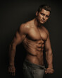 © Serge Lee - Male fitness model standing on black background with holding his pant's ropes