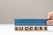 © Kenishirotie - Measure success word using blue ruler, representing a review, evaluation or assessment of an employee