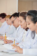 © DragonImages - Multi-ethnic group of scientists attending medical conference and talking notes when listening to speaker